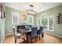 Elegant dining room with hardwood floors, large windows, modern chandelier, and stylish furnishings at 8728 E 25Th Dr, Denver, CO 80238