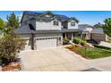 Charming gray two-story home featuring a well-maintained front yard with a three car garage at 22227 E Hinsdale Ave, Aurora, CO 80016