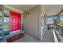 Charming front porch with stone accents, a bright red door, and a cozy spot to relax at 22227 E Hinsdale Ave, Aurora, CO 80016