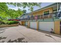 View of home featuring multiple garage spaces, yellow-painted walls, and a spacious driveway at 8300 W 67Th Ave, Arvada, CO 80004