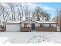 Brick ranch house with a white garage door and landscaped yard at 4198 E 117Th Ave, Thornton, CO 80233