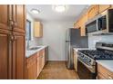 Modern kitchen with stainless steel appliances and wood cabinets at 4198 E 117Th Ave, Thornton, CO 80233