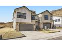 Townhome with a two-car garage, stone accents, and modern architectural design nestled in a hillside community at 1821 Grayside Cir, Castle Rock, CO 80109