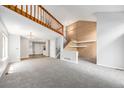 Open concept living area featuring a staircase, wood wall accents, and neutral carpet at 2238 S Nile Ct, Aurora, CO 80014