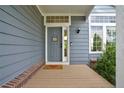Inviting front porch with a welcoming doormat and gray front door, complemented by brick accents at 2295 Sandhurst Dr, Castle Rock, CO 80104