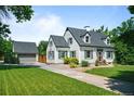 Beautiful home exterior with a detached garage and long driveway on a lush green lawn at 1033 Estes St, Lakewood, CO 80215