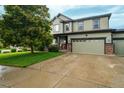 Inviting two-story home featuring a well-manicured lawn, two-car garage, and timeless exterior facade at 16747 E 97Th Pl, Commerce City, CO 80022