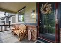 Cozy front porch featuring a wooden chair and decoratively adorned doorway at 16747 E 97Th Pl, Commerce City, CO 80022