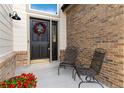 Charming front porch with brick accents, seating area, and welcoming front door with wreath at 9983 Cottoncreek Dr, Highlands Ranch, CO 80130
