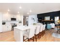 Spacious kitchen with white cabinets, a large island, stainless steel appliances, and wood floors at 9983 Cottoncreek Dr, Highlands Ranch, CO 80130