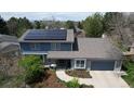 Aerial view of a charming two-story home featuring solar panels and an attached garage at 6062 S Emporia Cir, Englewood, CO 80111