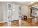 Bright foyer with hardwood floors and a unique glass block window at 6062 S Emporia Cir, Englewood, CO 80111
