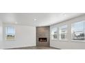 Living room with wood floors, stone fireplace, white trim, and natural light from the many windows at 1876 Chaffee Crest Dr, Berthoud, CO 80513