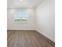 Bright room with wood floors, white trim, and natural light from the window at 1876 Chaffee Crest Dr, Berthoud, CO 80513