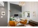 Stylish living room with a gray accent brick wall, hardwood floors, modern furniture, and large window at 505 Detroit St, Denver, CO 80206