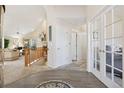 Inviting entryway featuring wood floors, white trim, and French doors leading to another room at 7134 W Belmont Dr, Littleton, CO 80123