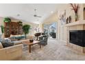 Spacious living room with a vaulted ceiling, fireplace, and sliding glass doors to the backyard at 7134 W Belmont Dr, Littleton, CO 80123