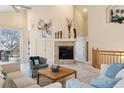 Bright living room featuring high ceilings, fireplace, neutral decor, and access to a patio at 7134 W Belmont Dr, Littleton, CO 80123