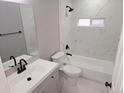 Clean bathroom with tub, shower, white vanity, and black fixtures at 4673 Sherman St, Denver, CO 80216