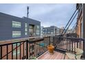 Apartment balcony with metal railing and view of surrounding buildings and blue swimming pool at 2960 Inca St # 404, Denver, CO 80202