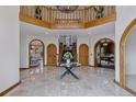 Grand foyer with marble floors, a striking staircase, and arched doorways leading to other rooms in the house at 5 Tamarade Dr, Littleton, CO 80127