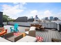 Relaxing rooftop deck area featuring modern outdoor furniture and a stunning city skyline view at 2589 Arapahoe St, Denver, CO 80205