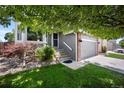 Inviting home exterior with brick accents, well-maintained lawn, and an attached two-car garage at 5750 S Youngfield St, Littleton, CO 80127