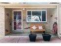 Inviting front porch with a bench, potted plants, and security door at the entrance at 1506 S Jersey St, Denver, CO 80224