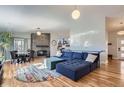 Open-concept living room with a brick fireplace, hardwood floors, and a comfortable blue sectional at 345 S Forest St, Denver, CO 80246