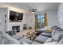 Comfortable living room with a fireplace, large television, grey sectional sofa, and access to a deck at 1671 W Canal Cir # 221, Littleton, CO 80120