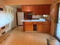 An older kitchen featuring wood cabinets and dated appliances, needing renovation to modernize its appearance and functionality at 8779 Santa Fe Dr, Thornton, CO 80260