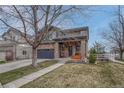 Charming two-story home with a stone facade, a two-car garage, and a covered front porch at 1192 S Fultondale Cir, Aurora, CO 80018
