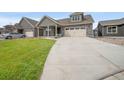 Exterior view of a home with a spacious concrete driveway leading up to a charming two-car garage at 331 Josef Cir, Fort Lupton, CO 80621