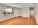 Spacious living room with hardwood flooring, abundant natural light, and neutral wall paint throughout the space at 5510 Troy St, Denver, CO 80239