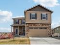 Inviting two-story home with stone accents, blue shutters and a two car garage at 2042 Shadow Creek Dr, Castle Rock, CO 80104