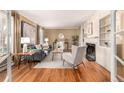 Bright living room features hardwood floors, neutral walls, fireplace, and large picture window at 3756 S Forest Way, Denver, CO 80237