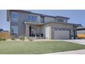 A landscaped front yard leads to the home's entrance and two-car garage at 14445 Hop Clover Trl, Parker, CO 80134