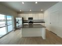 Modern kitchen with island, stainless steel appliances, and hardwood floors at 16602 E 109Th Ave, Commerce City, CO 80022