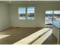 Bright and spacious living room with hardwood floors and large windows at 16602 E 109Th Ave, Commerce City, CO 80022