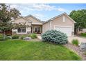 Beautiful home with a lush lawn and stone details leading to a welcoming front porch and attached garage at 21062 Hawthorne Ln, Parker, CO 80138