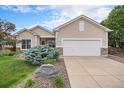 Inviting home exterior showcases a manicured lawn, stylish stone accents, and an attached two-car garage at 21062 Hawthorne Ln, Parker, CO 80138