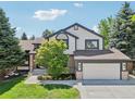 Charming two-story home featuring a well-manicured lawn, a two car garage and mature trees at 9810 Venneford Ranch Rd, Highlands Ranch, CO 80126