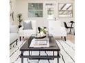 Open living room showcasing modern chairs, a coffee table with candles, and a view to the backyard at 1390 S Jasmine Way, Denver, CO 80224