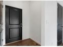 A clean and modern entryway features hardwood floors and a stylish black door at 2351 Monte Vista St, Fort Lupton, CO 80621