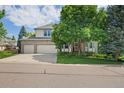 Inviting two-story home with brick accents, a three-car garage, and a beautifully landscaped front yard at 6506 S Robb Way, Littleton, CO 80127