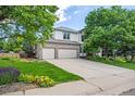 Charming two-story home with a well-manicured lawn, mature trees, and a spacious three-car garage at 6506 S Robb Way, Littleton, CO 80127