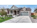 Beautiful home with a covered porch, stone accents, and two-car garage offering modern curb appeal at 6930 Hyland Hills St, Castle Pines, CO 80108