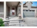Inviting front porch leading to the entrance and a view of the attached garage at 6930 Hyland Hills St, Castle Pines, CO 80108