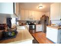 Well-lit kitchen features stainless steel appliances, butcher block countertops, and white cabinetry at 19258 E Kansas Dr, Aurora, CO 80017