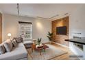 Bright living room featuring a sofa, track lighting, hardwood floors, and exposed brick at 2306 Glenarm Pl # 206, Denver, CO 80205